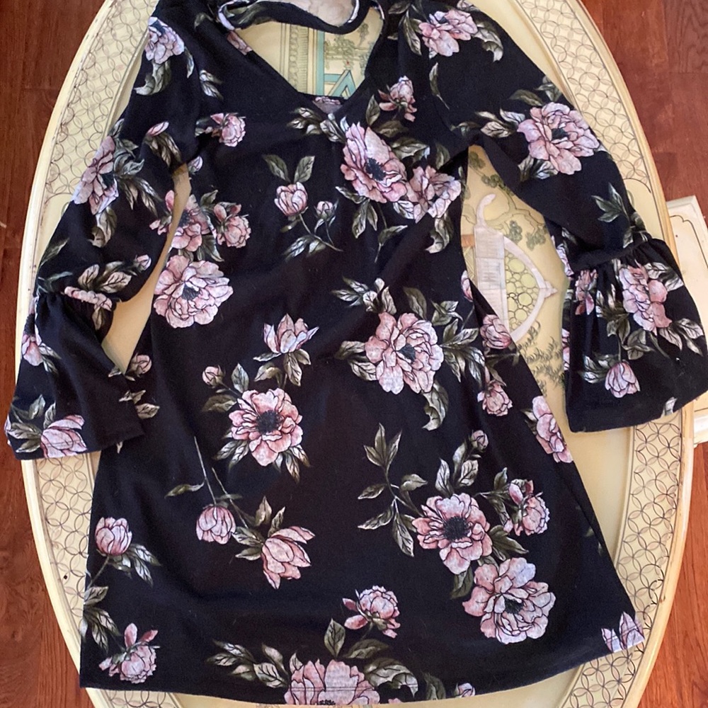 Small black dress with flowers.  Ties in the back, ruffled sleeve on the bottom